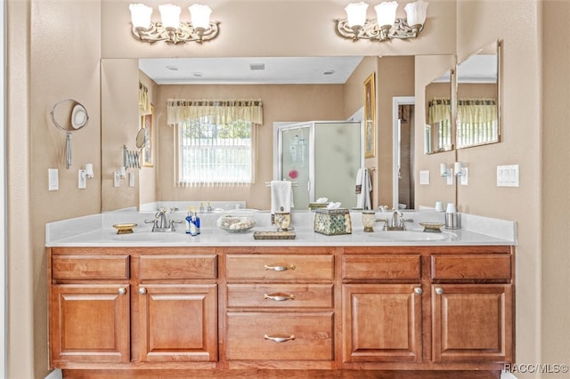 bathroom with vanity, an inviting chandelier, and a shower with door