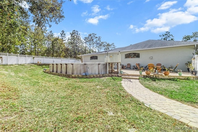 back of property with a yard and a patio