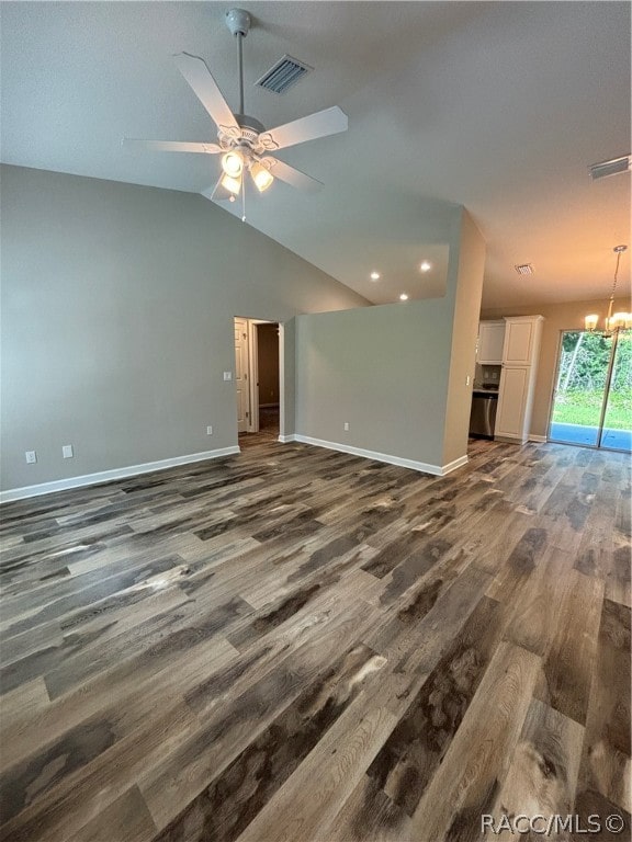 unfurnished living room featuring ceiling fan with notable chandelier, dark hardwood / wood-style flooring, and lofted ceiling