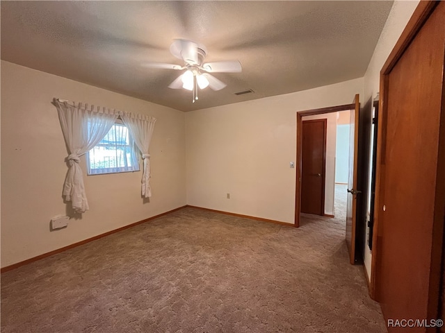 unfurnished room featuring ceiling fan, carpet floors, and a textured ceiling