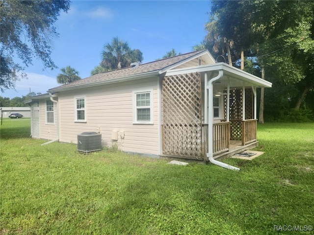 view of property exterior with central air condition unit and a lawn