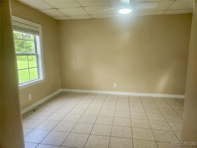 unfurnished room with a drop ceiling and light tile patterned flooring