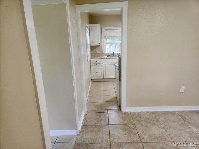 hall with sink and light tile patterned floors