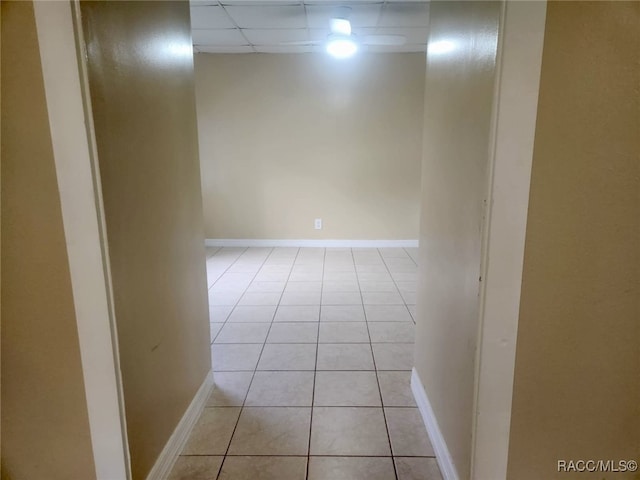 interior space featuring a paneled ceiling and light tile patterned flooring