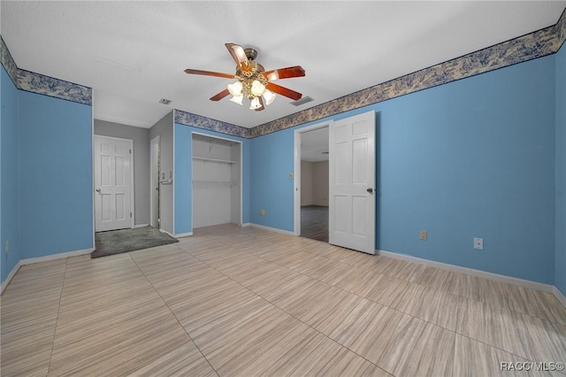 unfurnished bedroom featuring ceiling fan, a closet, visible vents, and baseboards