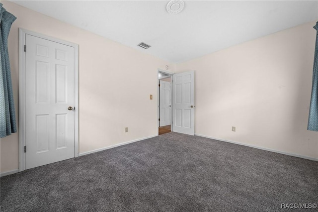 unfurnished bedroom featuring carpet, visible vents, and baseboards