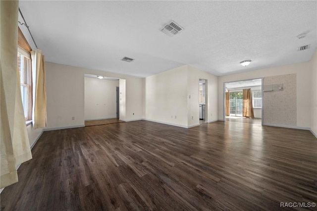 spare room with visible vents, dark wood finished floors, and baseboards