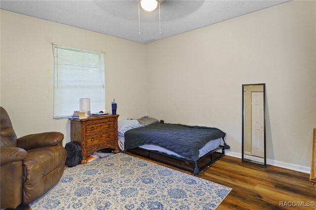 bedroom featuring ceiling fan and dark wood-type flooring