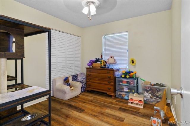 bedroom with a closet, ceiling fan, and dark wood-type flooring