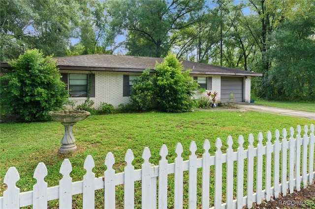 ranch-style house featuring a garage and a front lawn