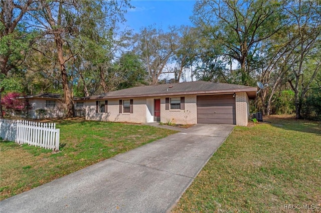 ranch-style house featuring a front yard, central AC unit, and a garage