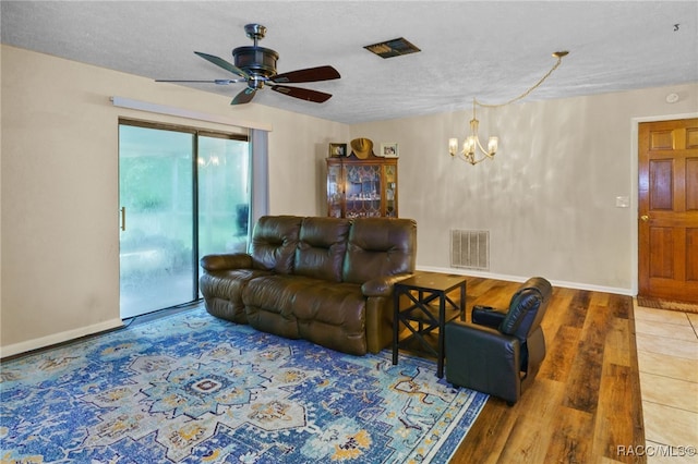 living room with a textured ceiling, ceiling fan with notable chandelier, and hardwood / wood-style flooring