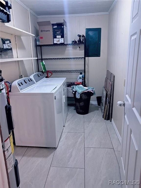 washroom featuring electric panel, washer and dryer, light tile patterned floors, ornamental molding, and water heater