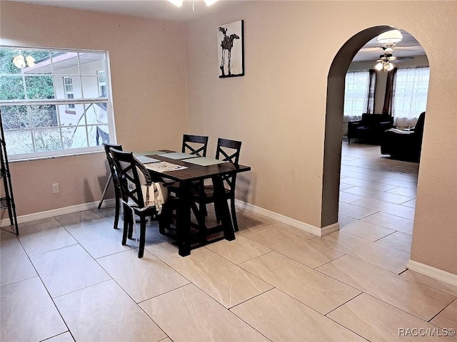 tiled dining space with ceiling fan