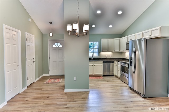 kitchen featuring pendant lighting, high vaulted ceiling, light hardwood / wood-style flooring, a notable chandelier, and stainless steel appliances