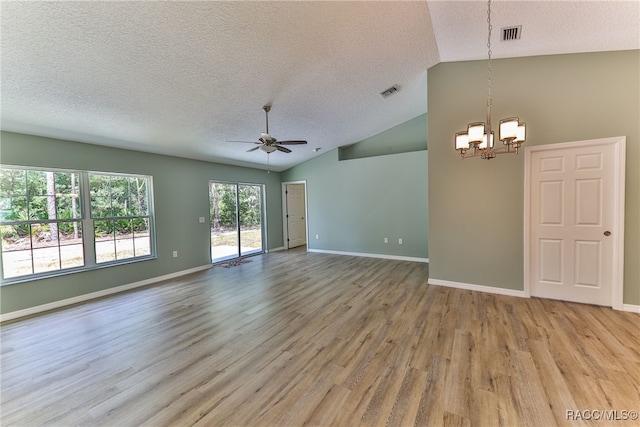 empty room featuring a textured ceiling, ceiling fan with notable chandelier, light hardwood / wood-style floors, and high vaulted ceiling