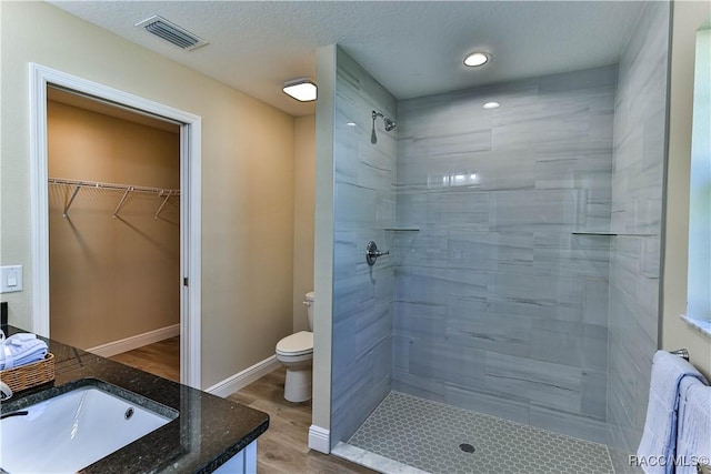 bathroom with visible vents, baseboards, toilet, a stall shower, and wood finished floors