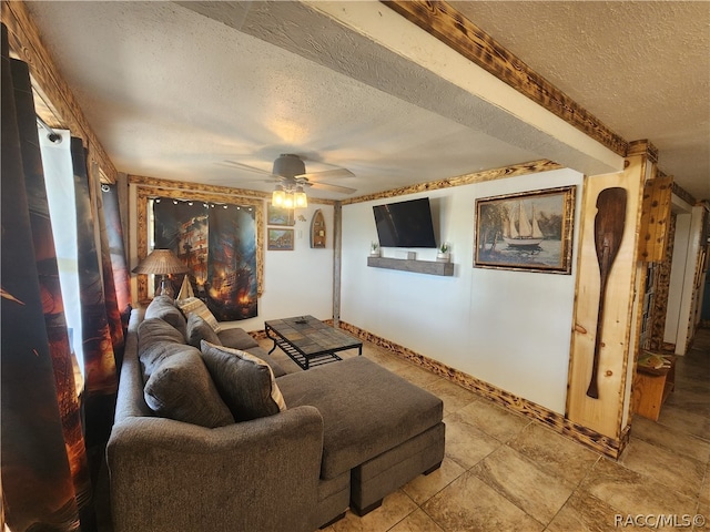 living room featuring ceiling fan and a textured ceiling