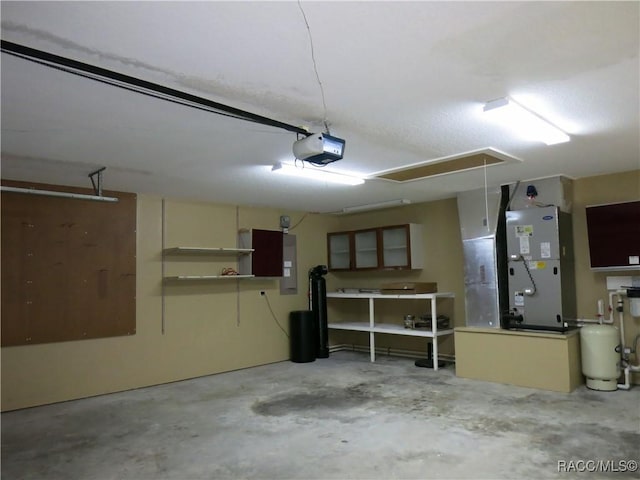 garage featuring heating unit, a garage door opener, and electric panel