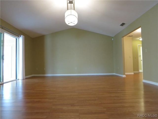 unfurnished room featuring vaulted ceiling and hardwood / wood-style floors