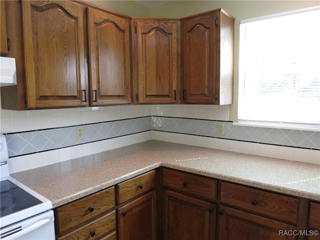 kitchen with white electric range oven and backsplash