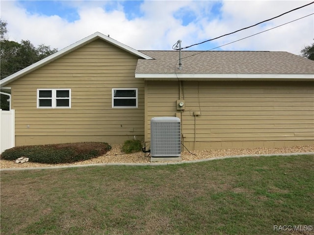 rear view of property with a yard and central AC