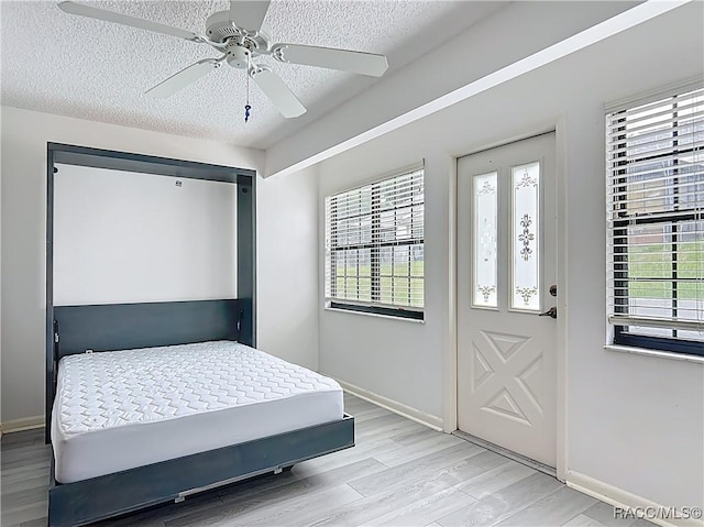 3328 S Whitechappel Pt, Inverness, FL 34452 - bedroom with a textured ceiling, light wood-style floors, and a ceiling fan