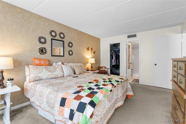 bedroom featuring a spacious closet, a closet, and light colored carpet