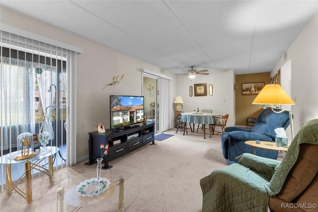 carpeted living room featuring ceiling fan and a textured ceiling