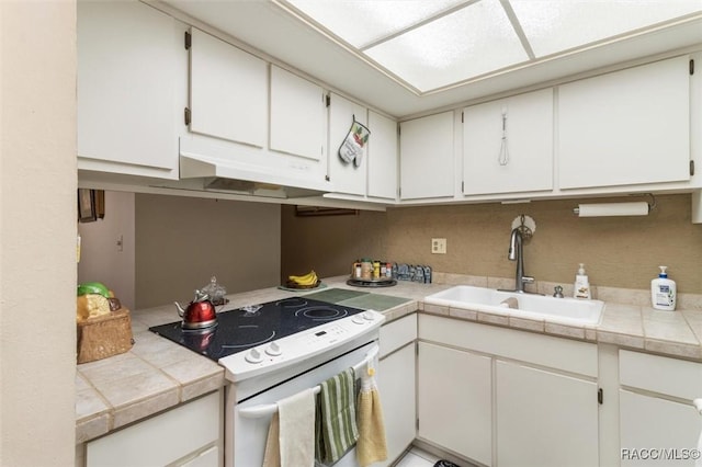 kitchen featuring tile countertops, white range with electric stovetop, white cabinets, and sink