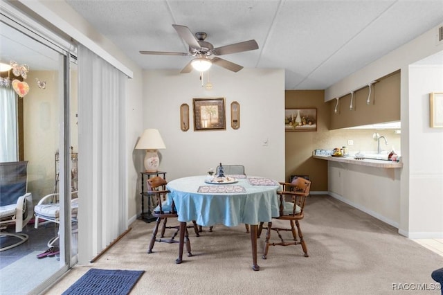 dining area featuring light carpet and ceiling fan