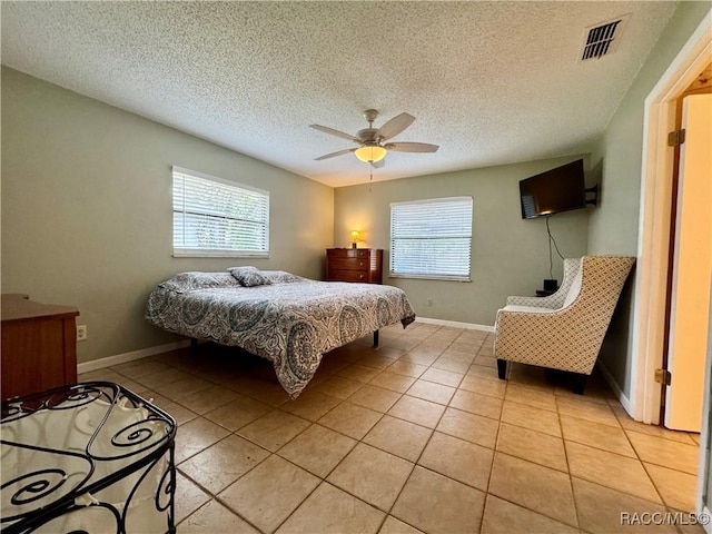 bedroom featuring light tile patterned flooring, visible vents, multiple windows, and ceiling fan