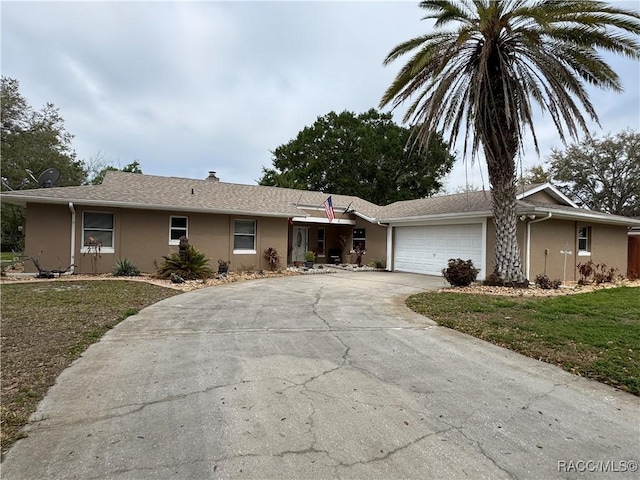 ranch-style home with stucco siding, driveway, a front yard, and a garage