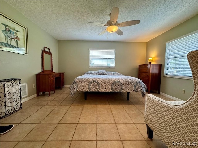 bedroom featuring light tile patterned floors, visible vents, multiple windows, and ceiling fan