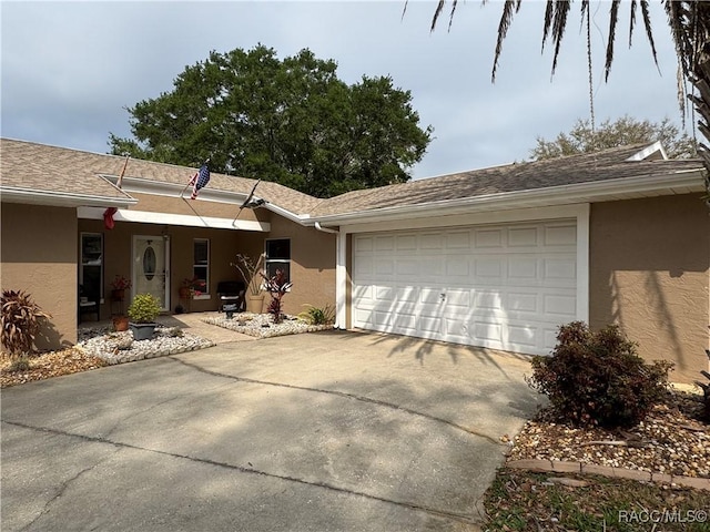 view of front of property featuring stucco siding, an attached garage, roof with shingles, and driveway