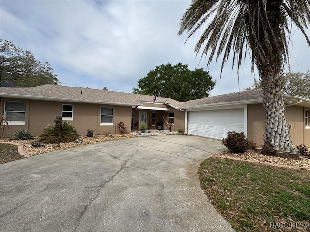 ranch-style house featuring an attached garage, driveway, and stucco siding