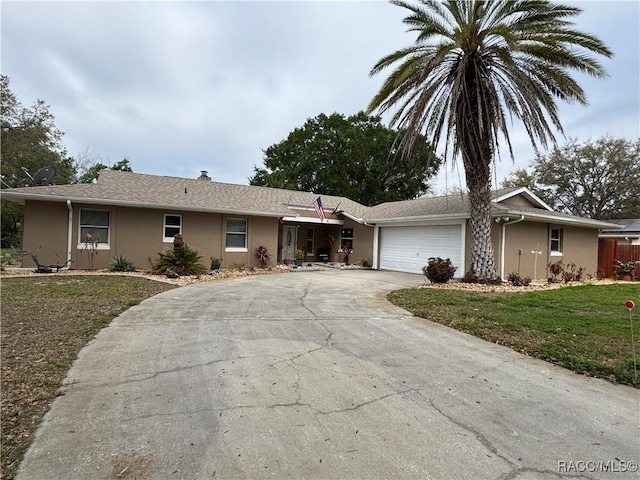 single story home featuring stucco siding, driveway, a front yard, and an attached garage