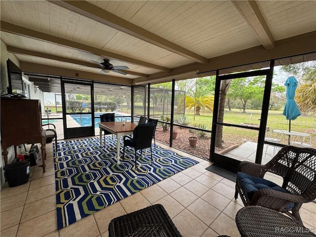 sunroom / solarium with beamed ceiling, plenty of natural light, and ceiling fan