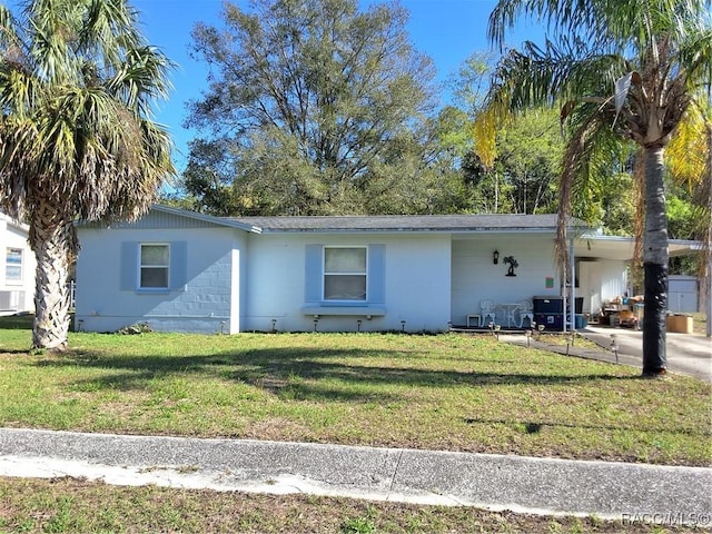 single story home with a front yard, driveway, and an attached carport