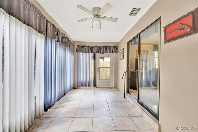 unfurnished sunroom featuring ceiling fan