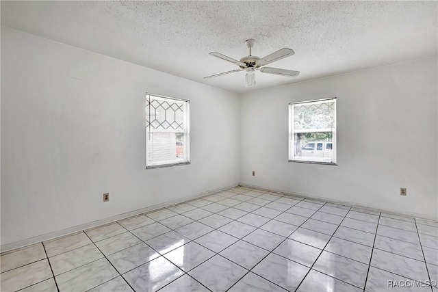 empty room featuring a textured ceiling and ceiling fan