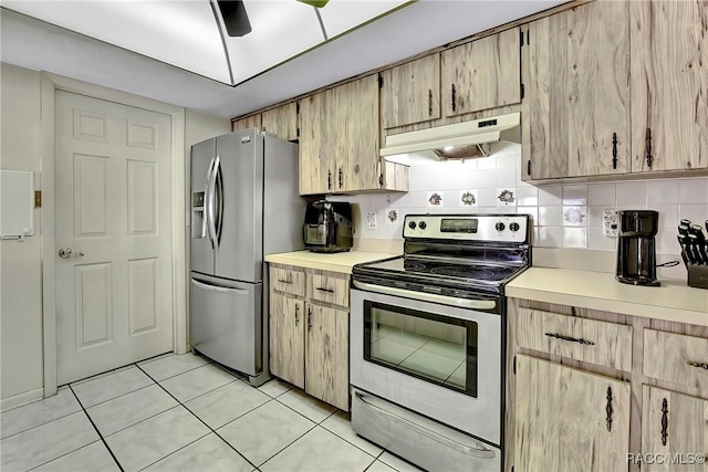 kitchen with appliances with stainless steel finishes, light tile patterned floors, light brown cabinets, and backsplash