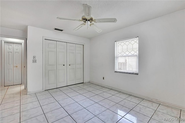 unfurnished bedroom with ceiling fan and a closet