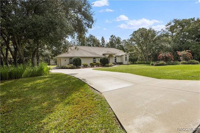 5799 N Oakmont Dr, Beverly Hills, FL 34465 - ranch-style home featuring curved driveway, a front lawn, and stucco siding