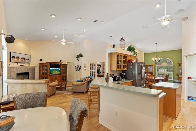 5799 N Oakmont Dr, Beverly Hills, FL 34465 - kitchen with stainless steel refrigerator with ice dispenser, ceiling fan, light wood finished floors, glass insert cabinets, and high vaulted ceiling