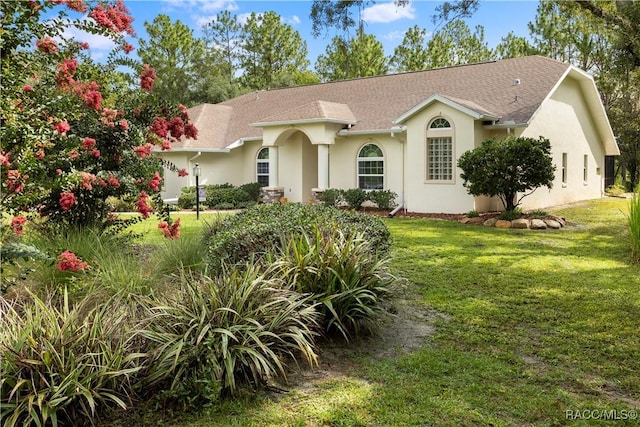 5799 N Oakmont Dr, Beverly Hills, FL 34465 - view of front facade featuring stucco siding, a front lawn, and a shingled roof