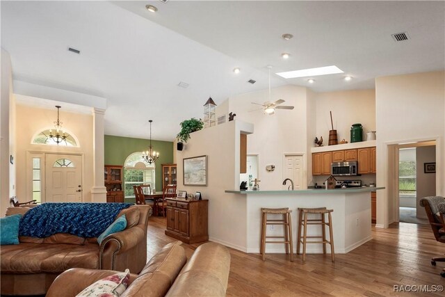 5799 N Oakmont Dr, Beverly Hills, FL 34465 - living area featuring a chandelier, light wood-style flooring, a ceiling fan, and high vaulted ceiling
