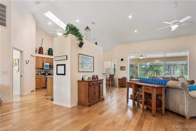 5799 N Oakmont Dr, Beverly Hills, FL 34465 - living room featuring a ceiling fan, high vaulted ceiling, light wood-style floors, and a skylight