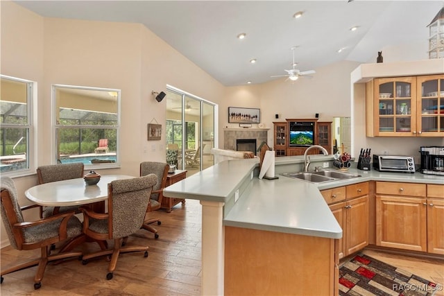 5799 N Oakmont Dr, Beverly Hills, FL 34465 - kitchen featuring a peninsula, light wood-type flooring, a ceiling fan, a tile fireplace, and lofted ceiling