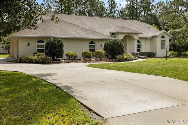 5799 N Oakmont Dr, Beverly Hills, FL 34465 - ranch-style home featuring stucco siding, driveway, a front yard, and a shingled roof